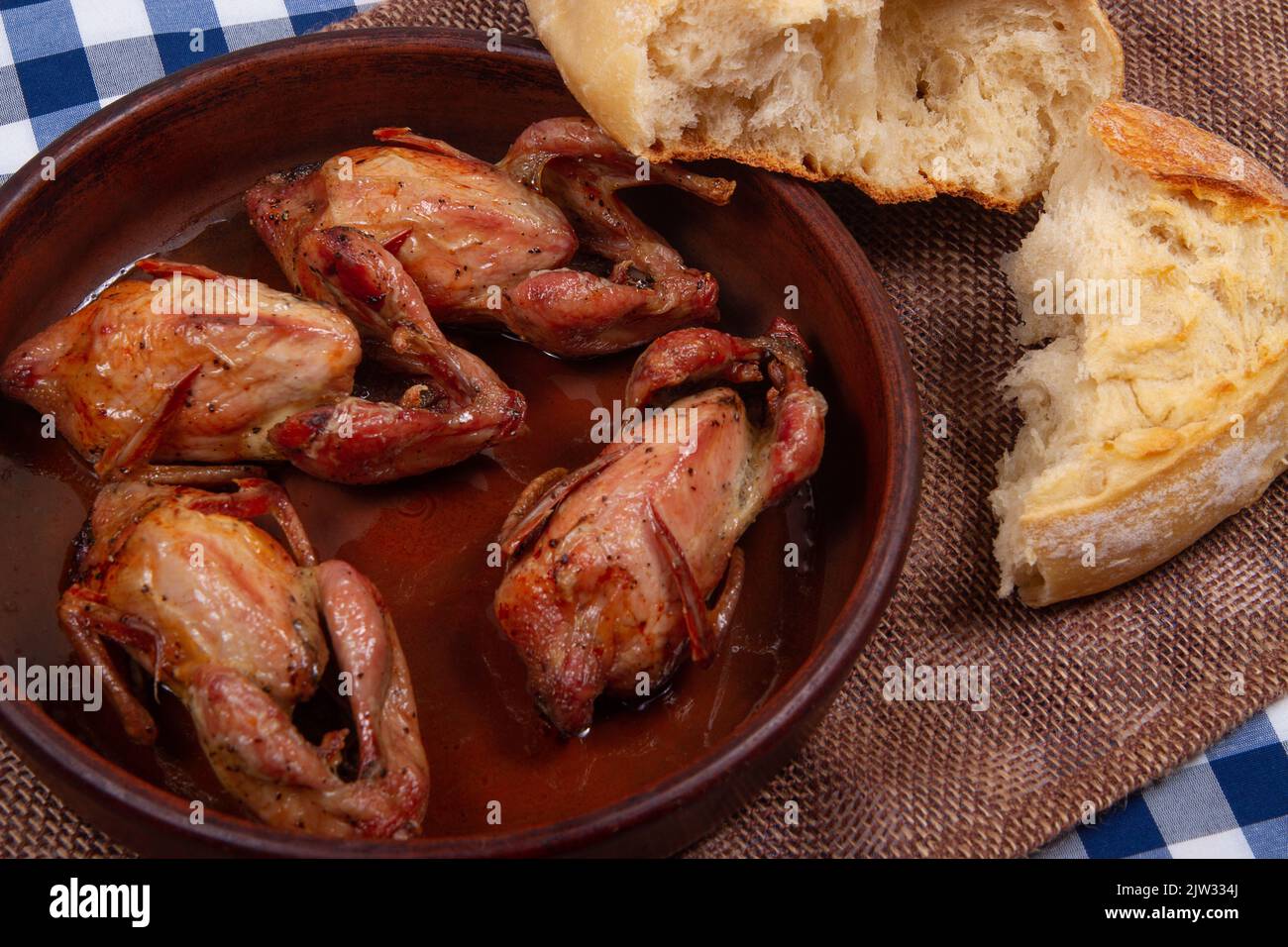 Rustic dinner. Roasted quail meat and white bread Stock Photo Alamy
