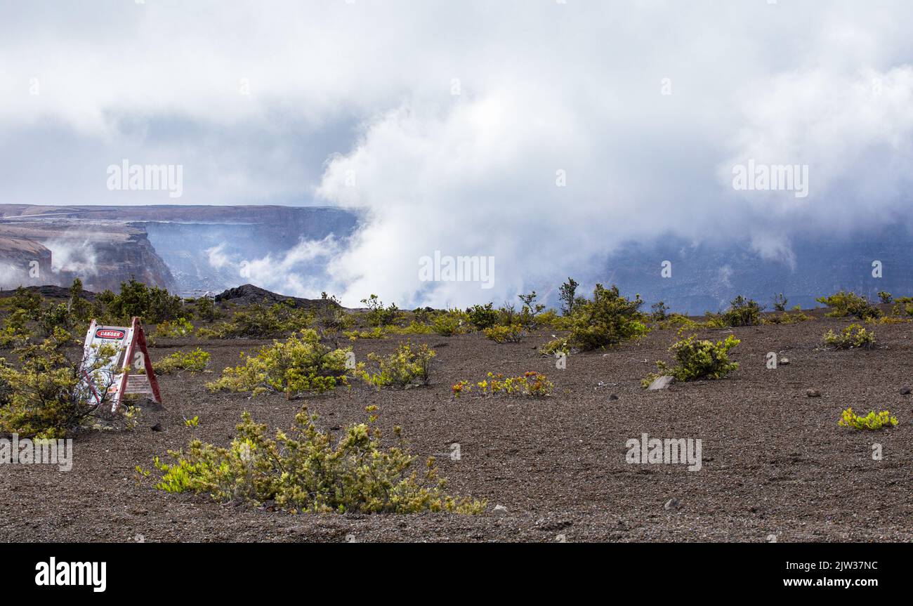 Steam and smoke rise from the mighty Halemaumau Crater. The lava lake in the crater floor is still active. This is a sacred place. Stock Photo