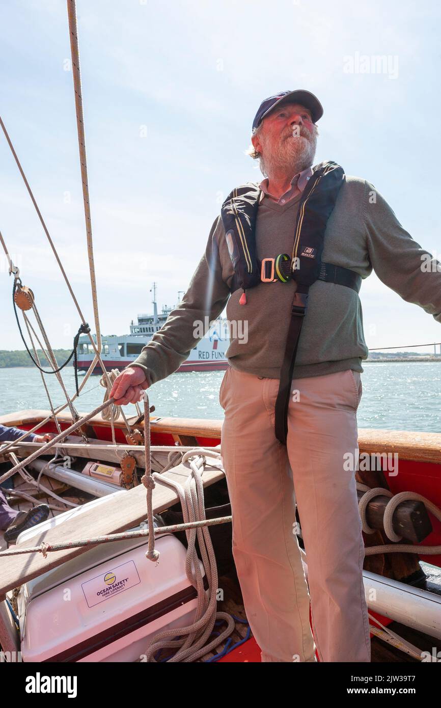 Crew member checking the rig of the traditional gaff cutter 'Jolie Brise', sailing on the Solent, Hampshire, UK Stock Photo