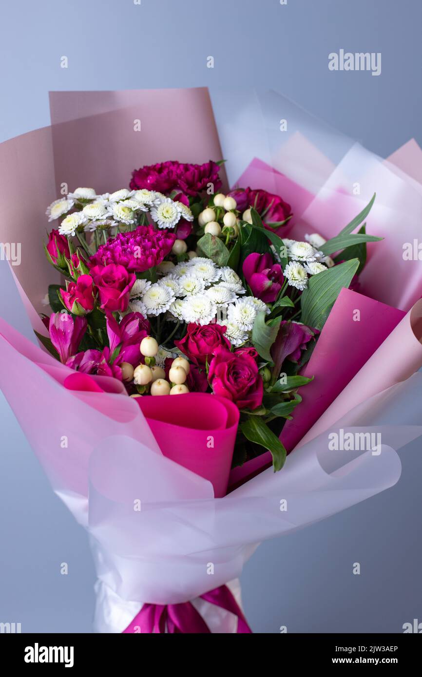 Beautiful bouquet of purple and white flowers with wrapping paper and  ribbons on white isolated background Stock Photo - Alamy