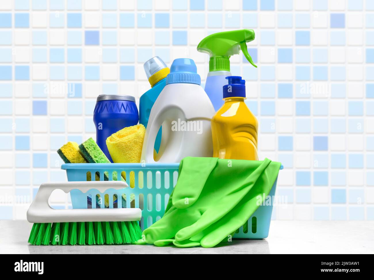 Cleaning supplies in plastic box on white table in the bathroom Stock Photo