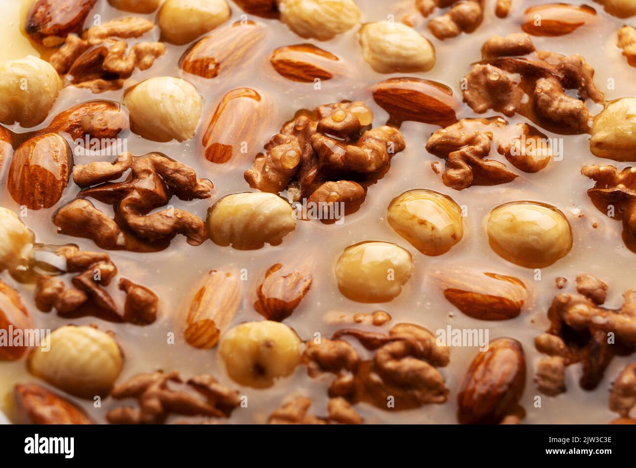 Honeyed assorted nuts organic food background flat view Stock Photo