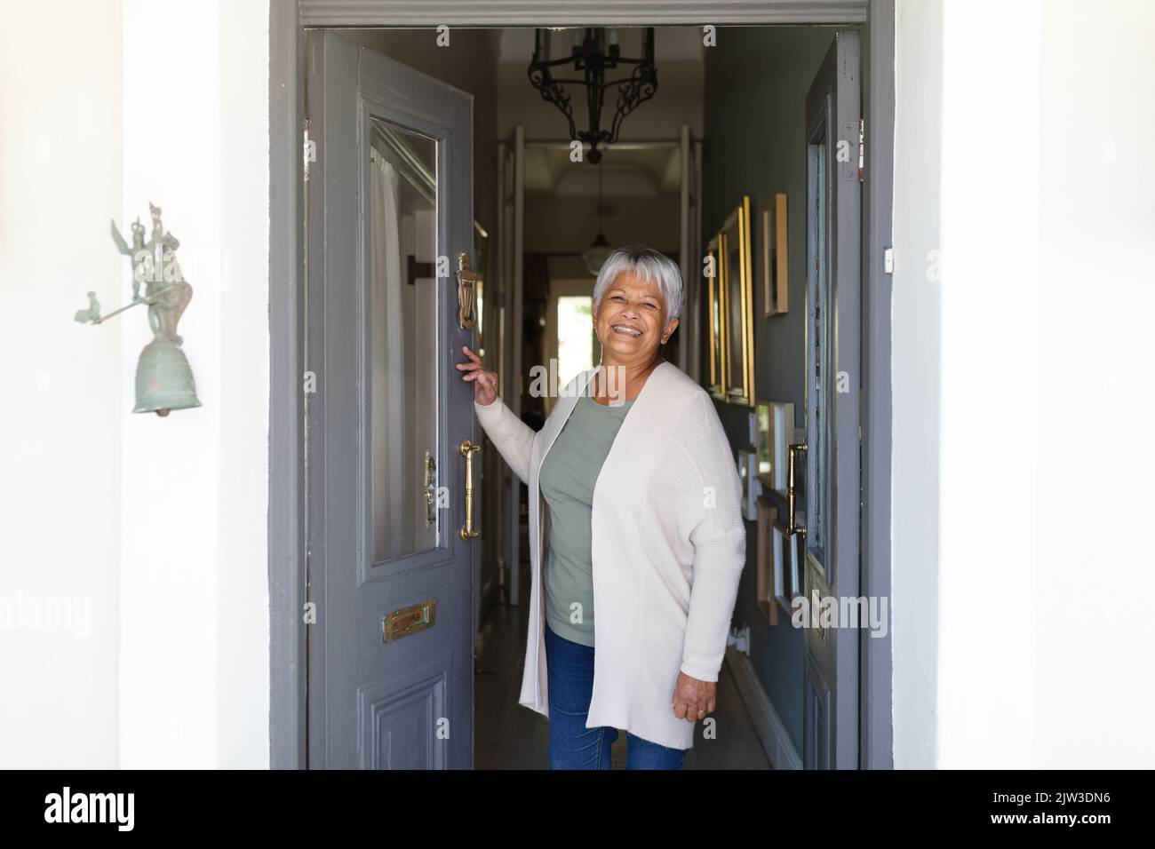 Portrait of senior african american woman standing in door looking at ...