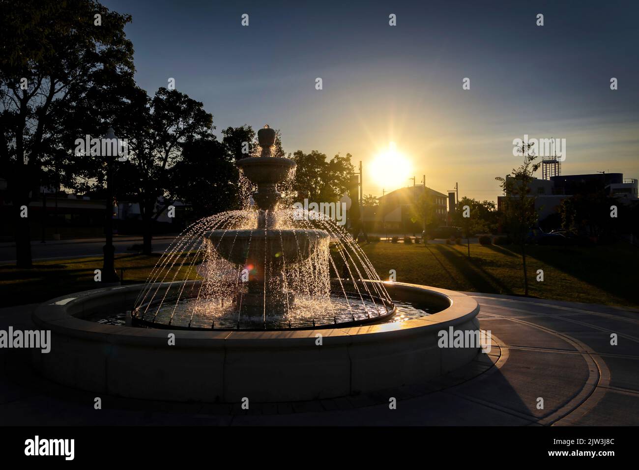 The morning sun warms a fountain in the downtown area of Manitowoc, Wisconsin. Stock Photo