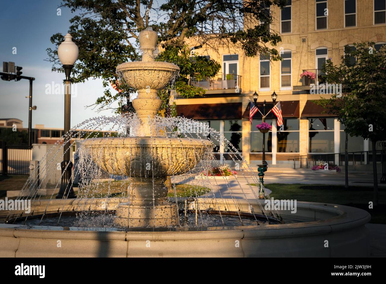 The morning sun warms a fountain in the downtown area of Manitowoc, Wisconsin. Stock Photo