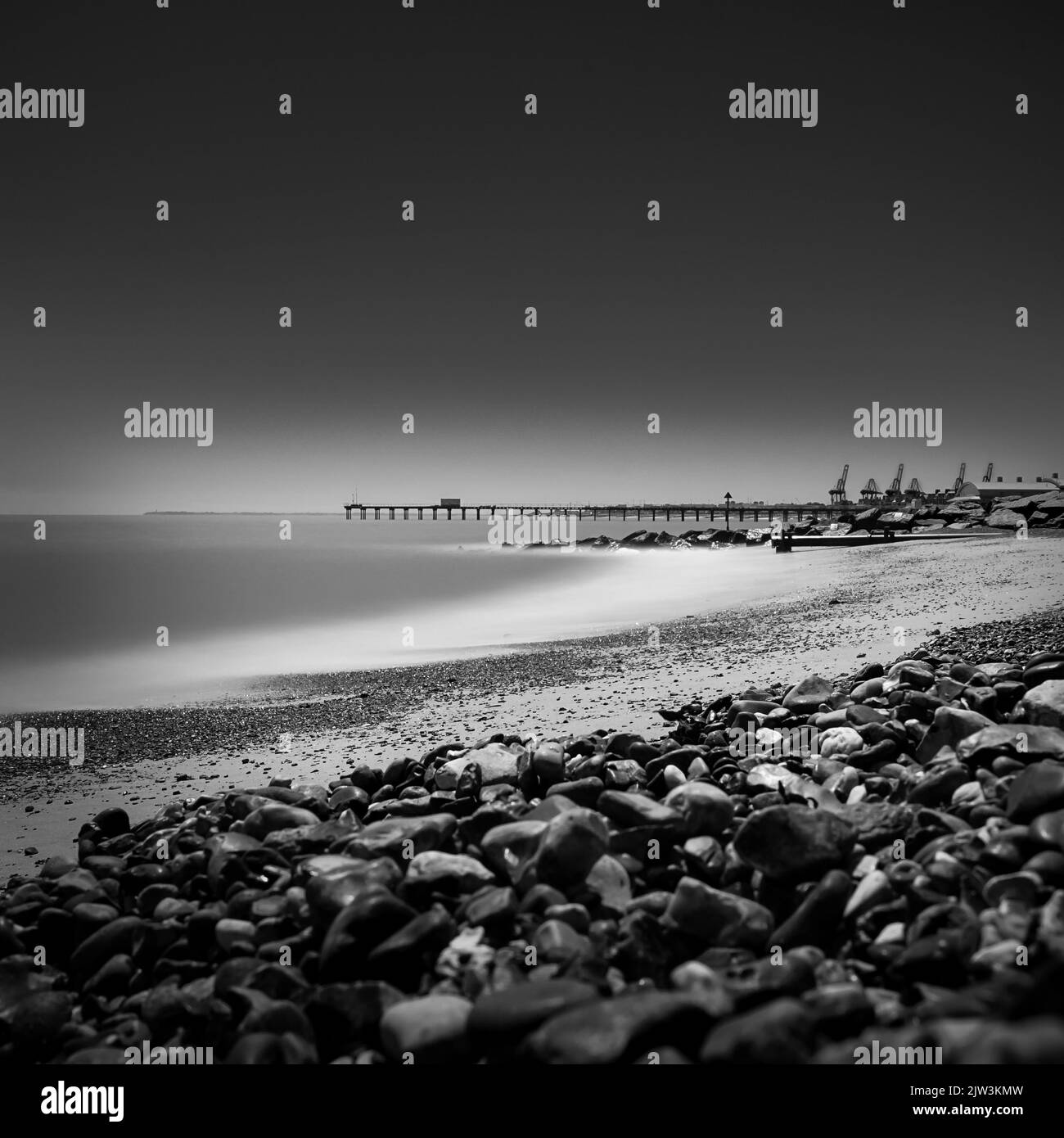A black and white shot of rocks on the beach Stock Photo - Alamy