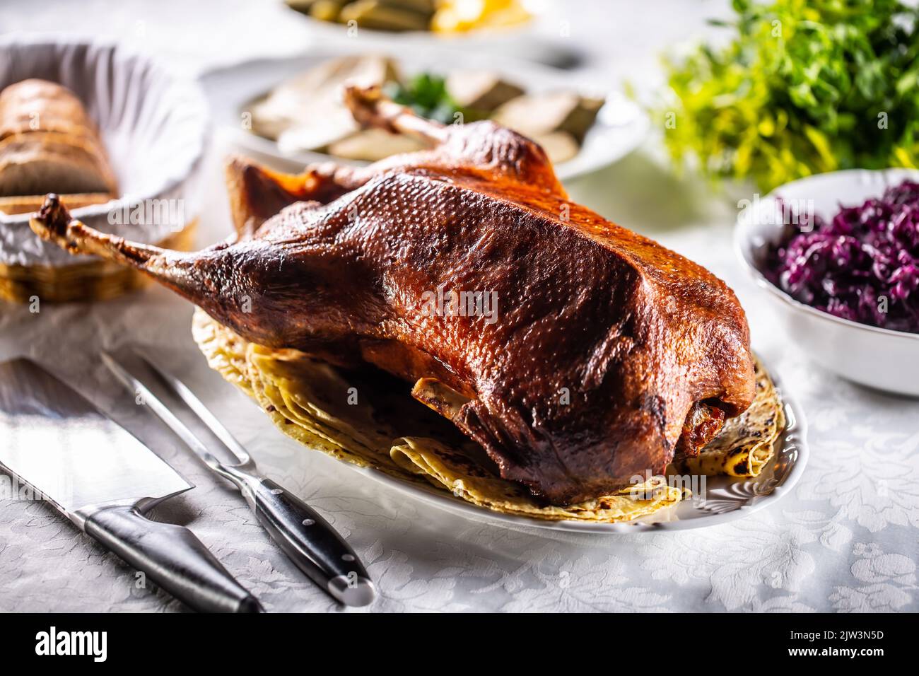 Roast goose with side dishes, red cabbage, roast, strudel, potato dumplings, pickles and bread. Stock Photo