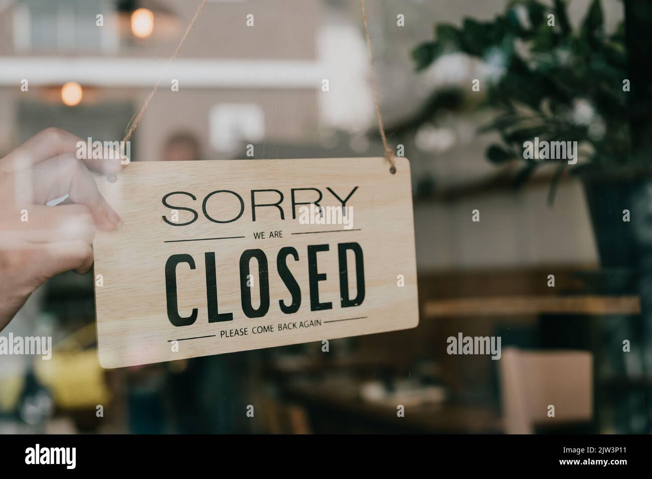 Business coffee cafe shop sign board is hang on door and show close shop with cafe and restaurant blur bokeh background. Stock Photo