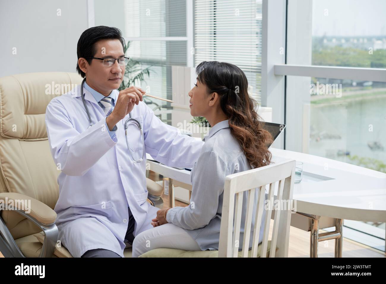 Doctor asking female patient to open mouth so he could check her throat Stock Photo Alamy