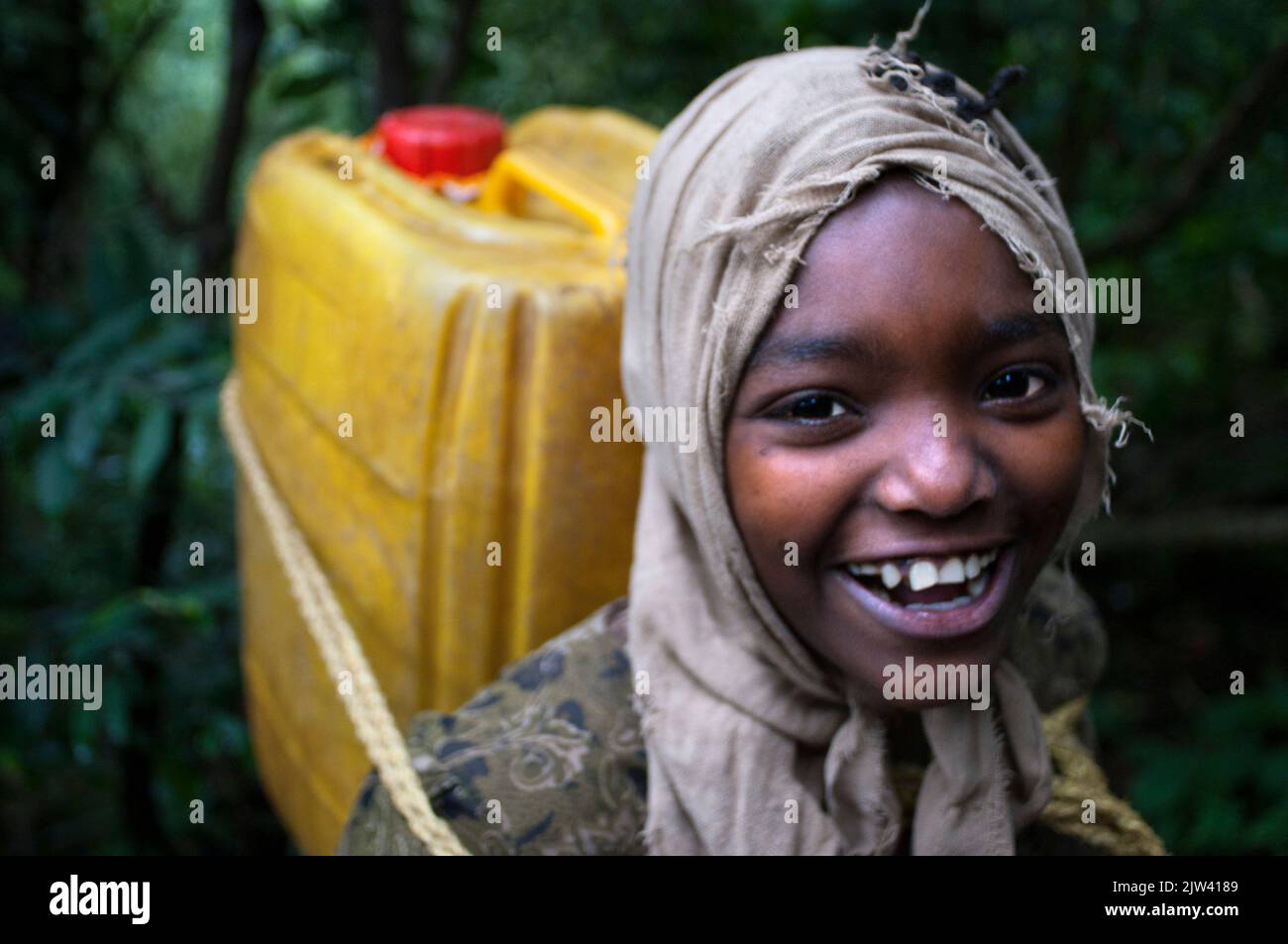 Kenya is characterized is characterized by long periods of drought and lack rivers flow.   A girl draws water from the Enziu River near Kitui, Kenya. Stock Photo