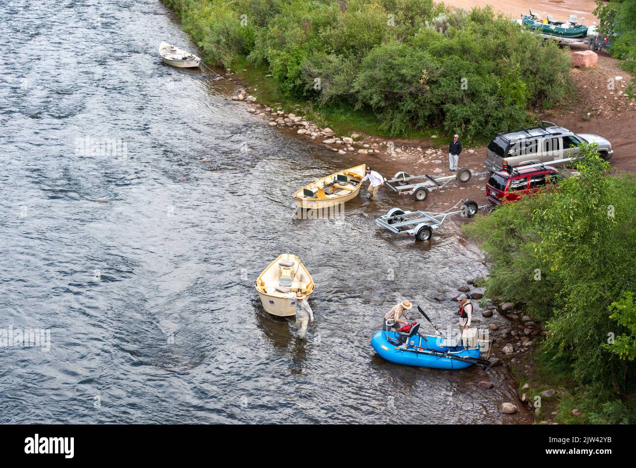 Two automobiles with trailers launching small fishing boats onto the Roaring Fork River in Carbondale, Colorado, USA. Stock Photo