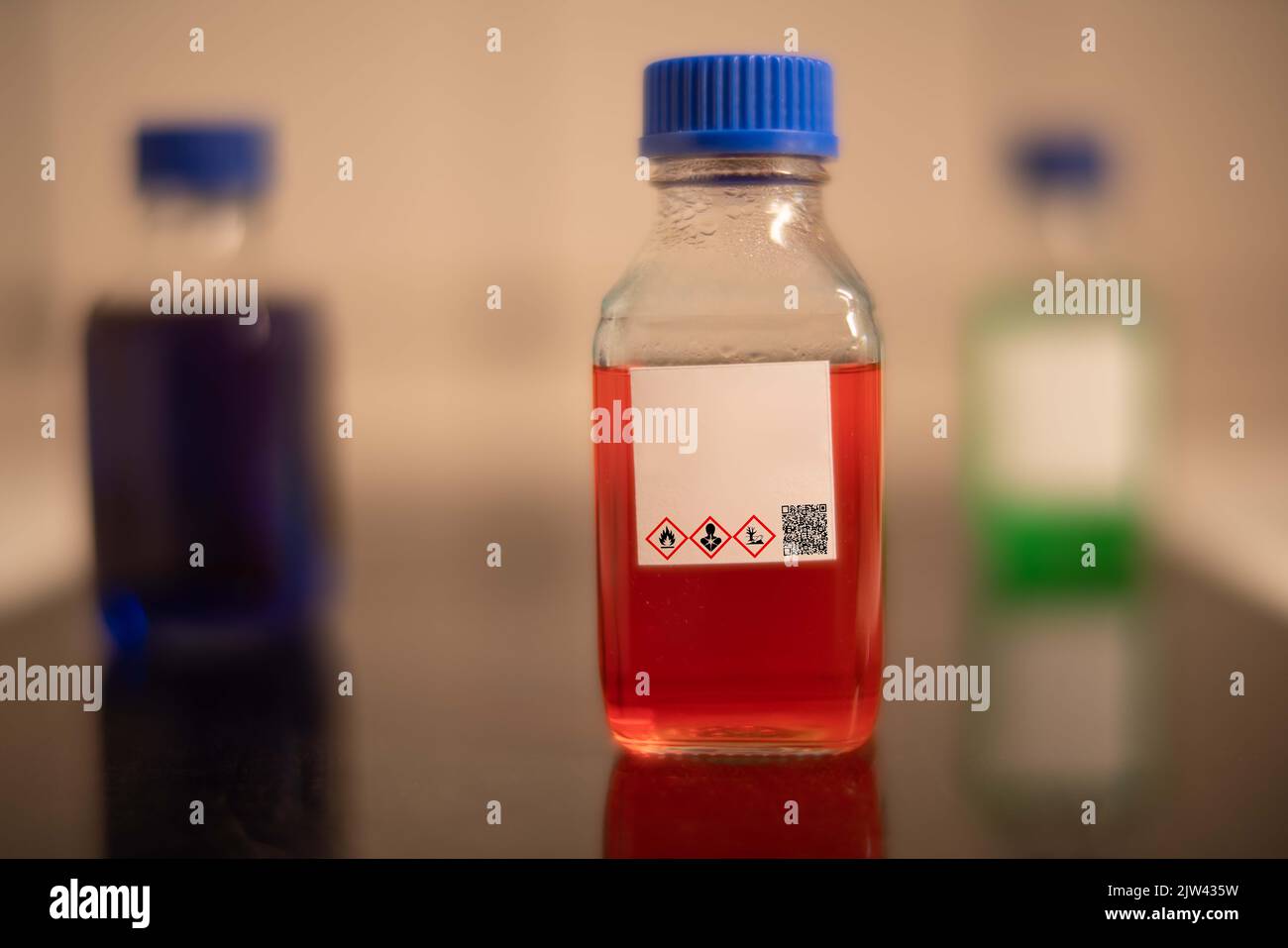 chemical solution glass bottles warning with hazard signs Stock Photo