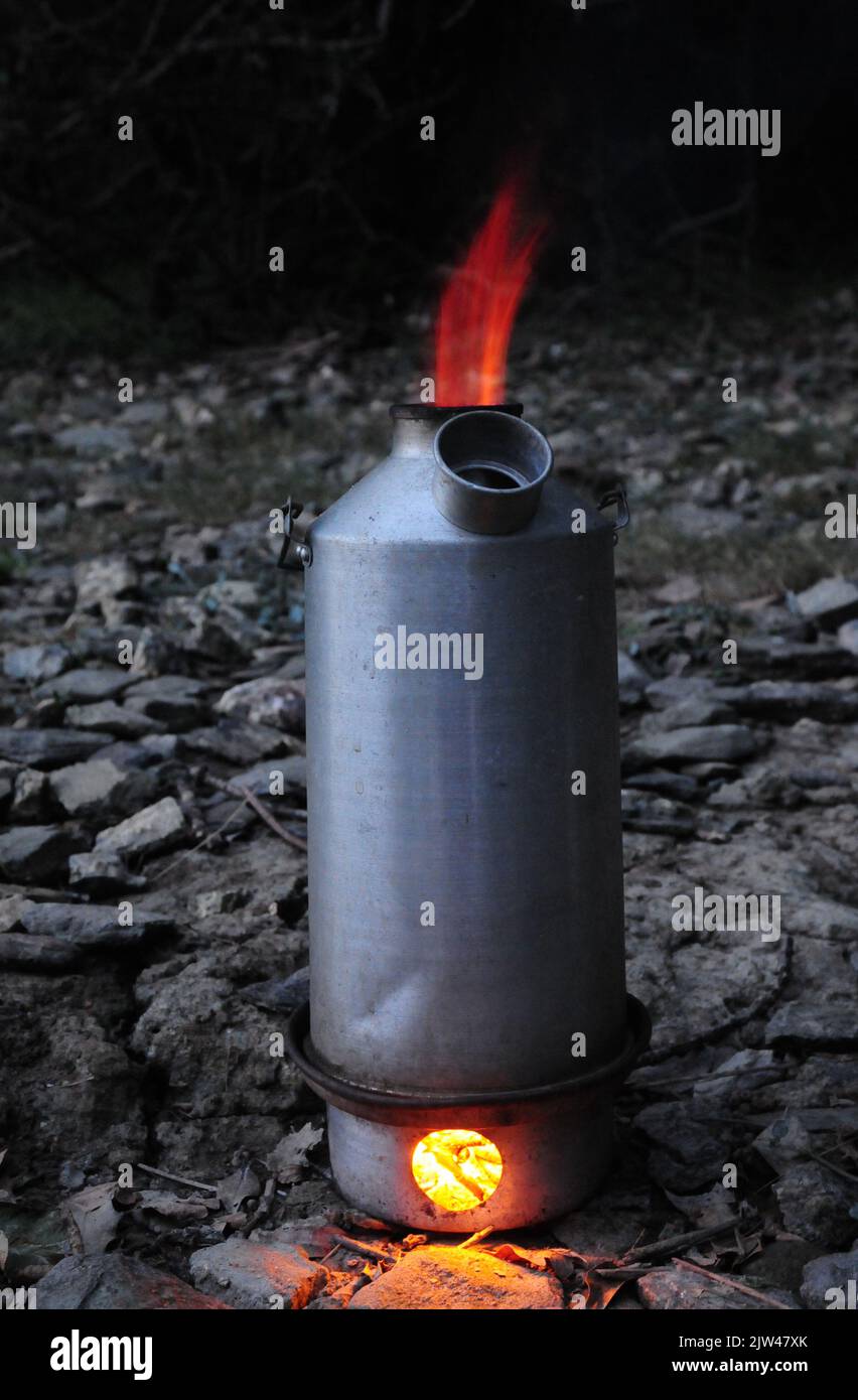 A Kelly kettle, also known as a storm kettle, roars with flames to boil
