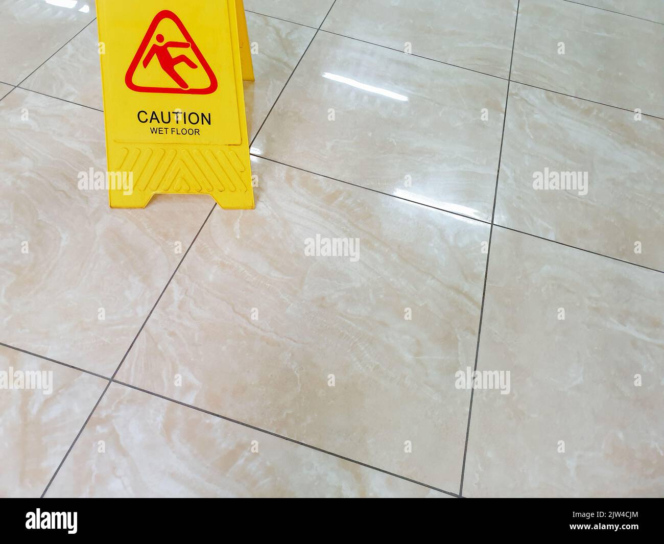 Wet floor with caution slippery sign. Incident warning. Office worker ...