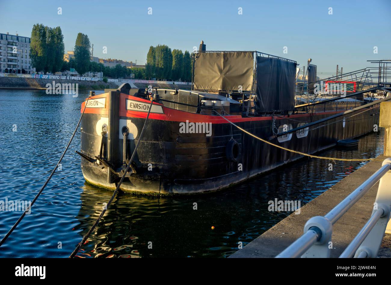Paris, France - May 27, 2022: Boat called Evasion moored on bank of River seine in evening sunlight Stock Photo