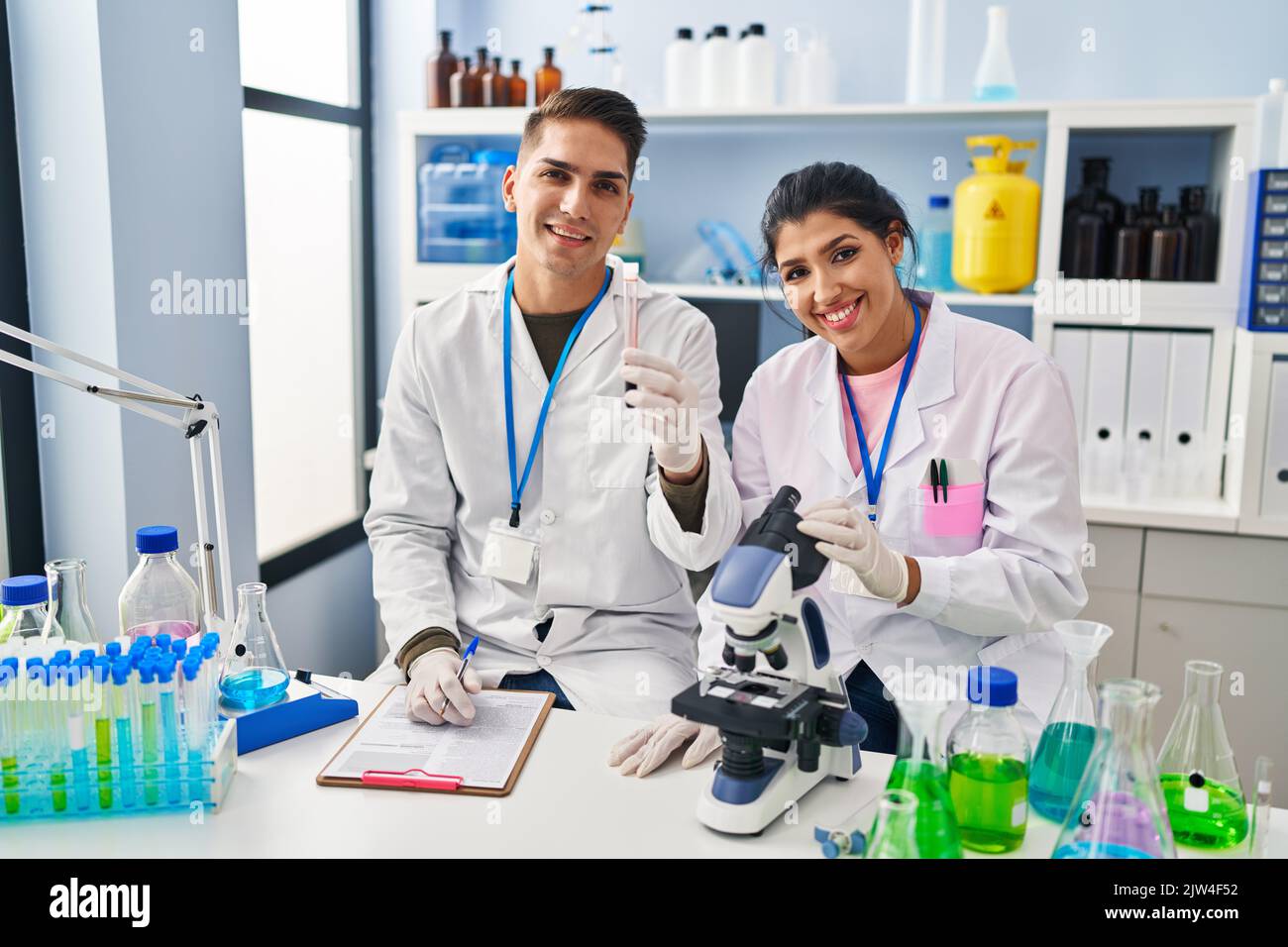 Man and woman scientists partners analysing blood test tube at ...
