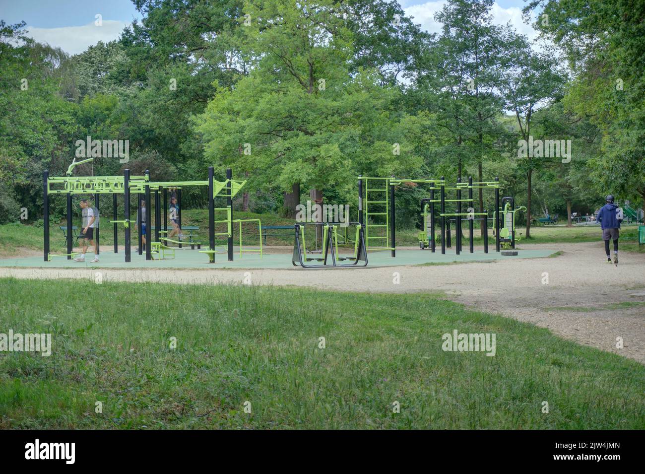 Paris, France - May 29, 2022: Outdoor gymnasium equipment for public use in Boise de Boulogne with motion blurred people exercising Stock Photo