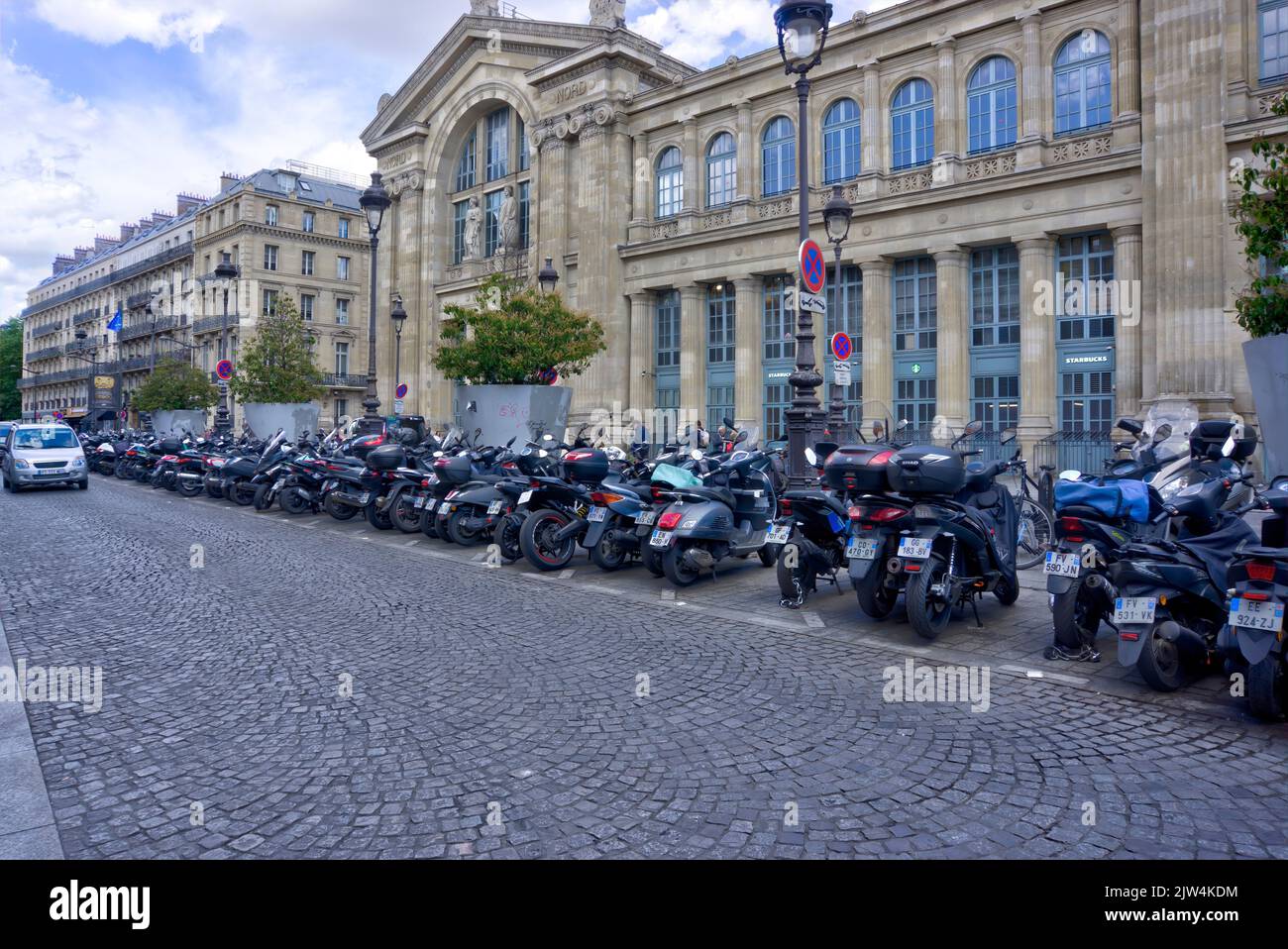 Paris, France - May 30, 2022: Exterior of Gare du Nord rail station with large row of parked motorcycles and scooters in foreground Stock Photo