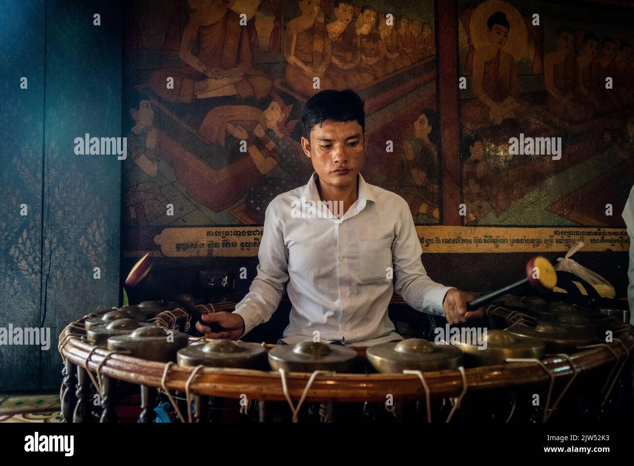 A member of a band plays a traditional Khmer musical instrument while ...