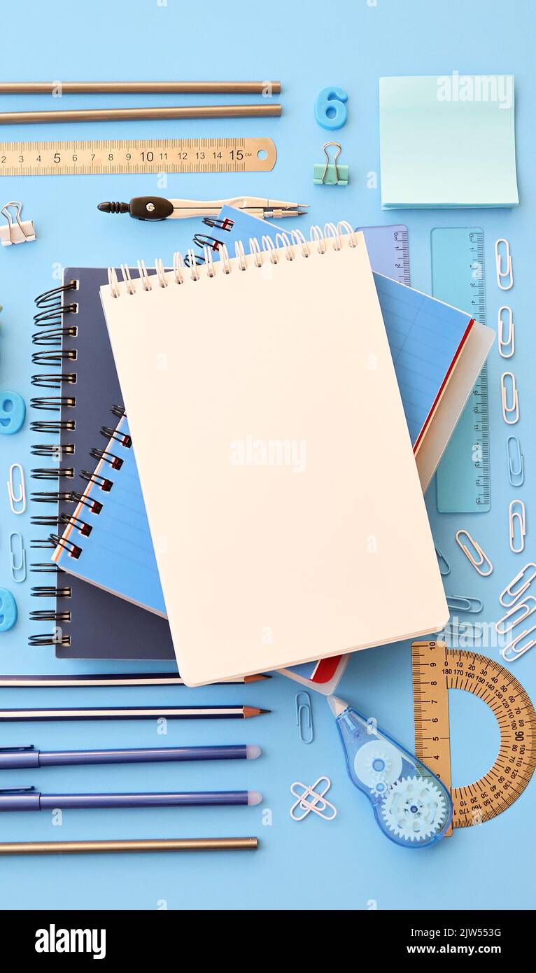 Stationery school supplies accessories on blue background, vertical