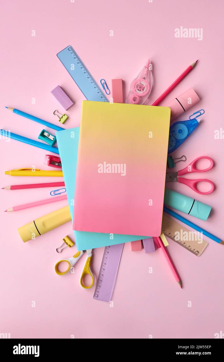 Pink notebooks and school supplies products accessories on pastel