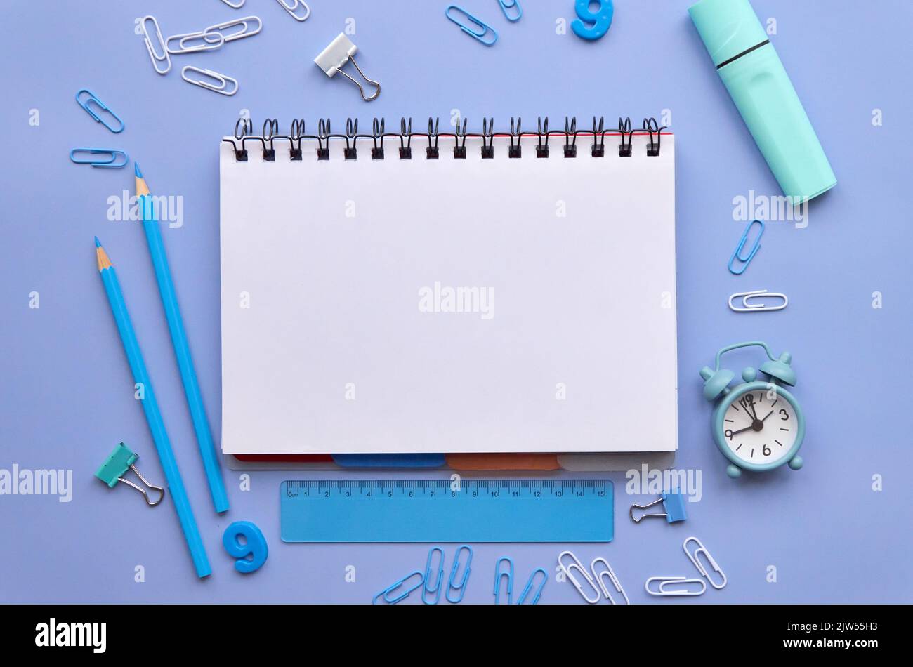 School stationery and open notebook on pastel lavender background, flatlay. Stock Photo