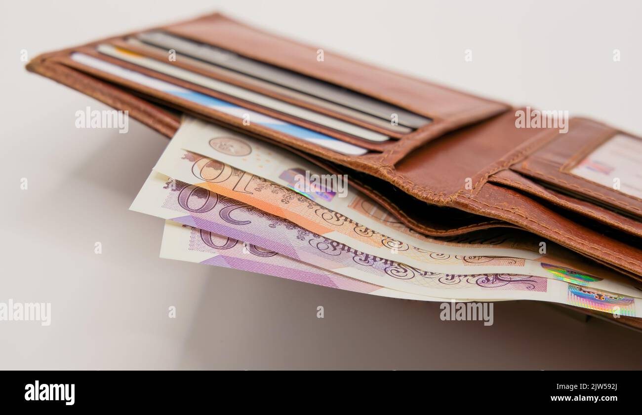 a light brown leather wallet with bank cards and a detailed closeup of