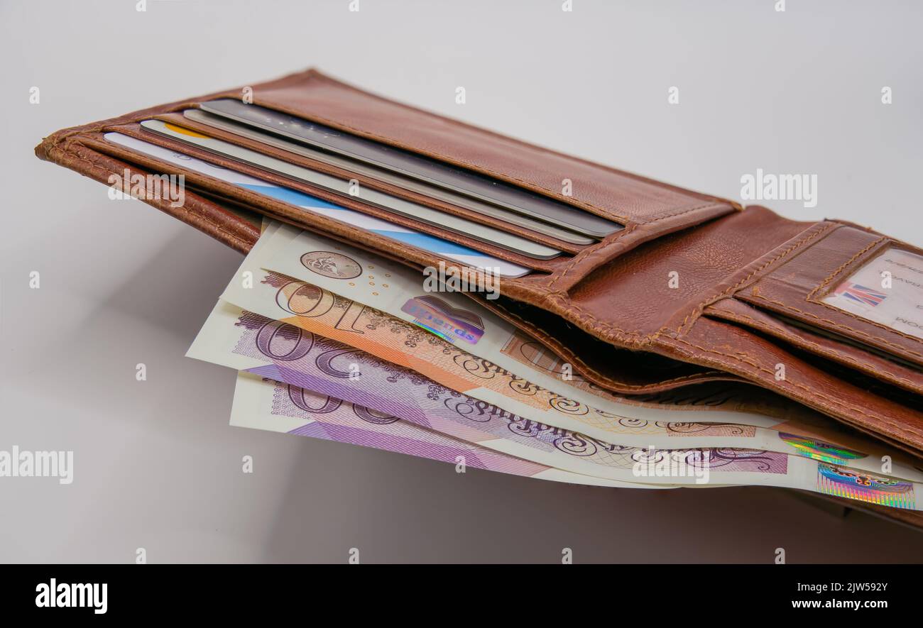 a light brown leather wallet with bank cards and a detailed closeup of