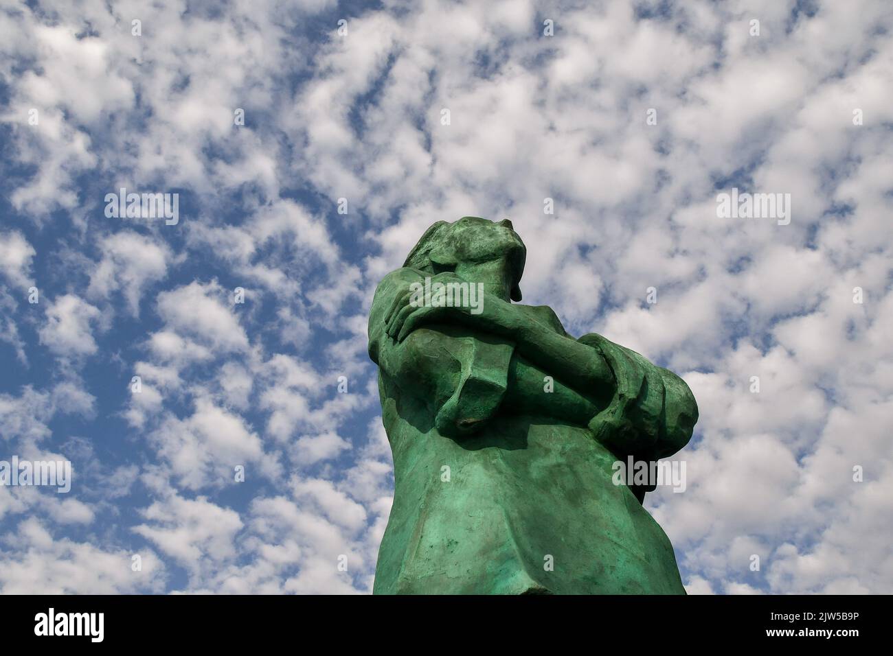 Low-angle view of the big bronze statue The Sailor in the harbour of the fishing village against clear blue sky, San Vincenzo, Livorno, Tuscany, Italy Stock Photo
