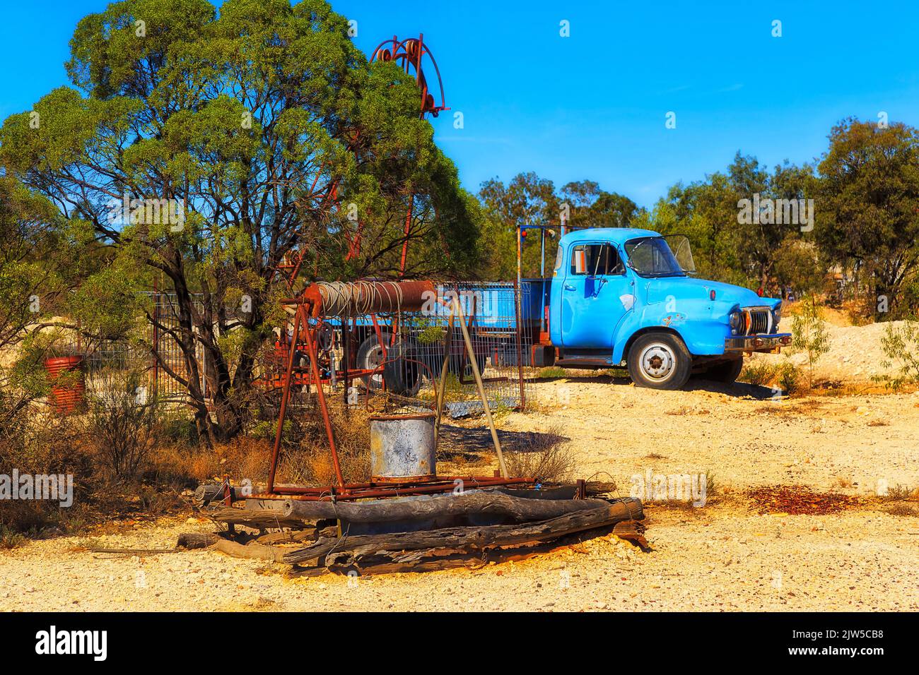 Old open mine shaft well and rust ute truck in Lightning ridge opal mining town of NSW outback, Australia. Stock Photo