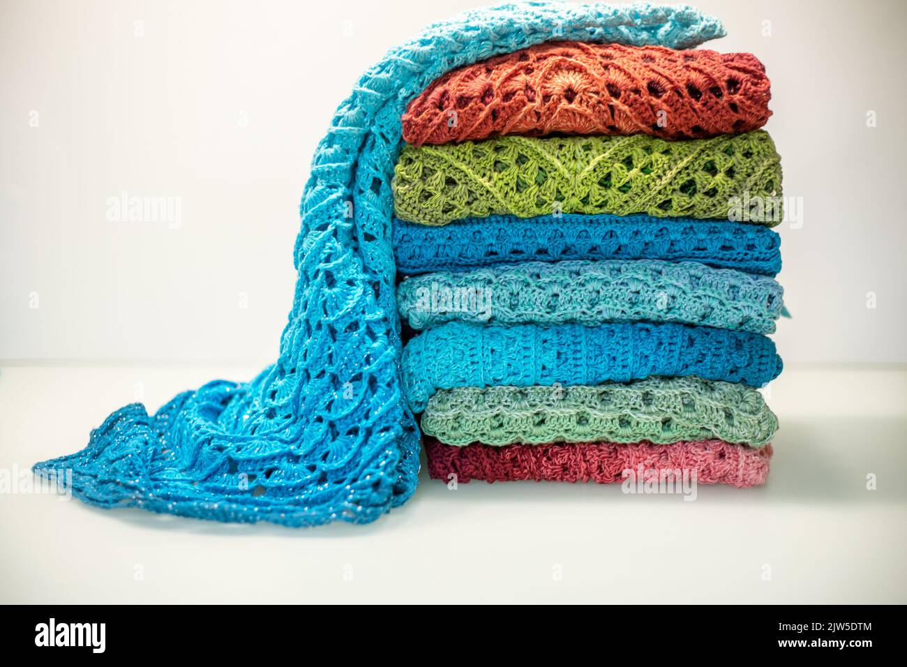 a stack of multi-colored knitted things on a white background. Stock Photo
