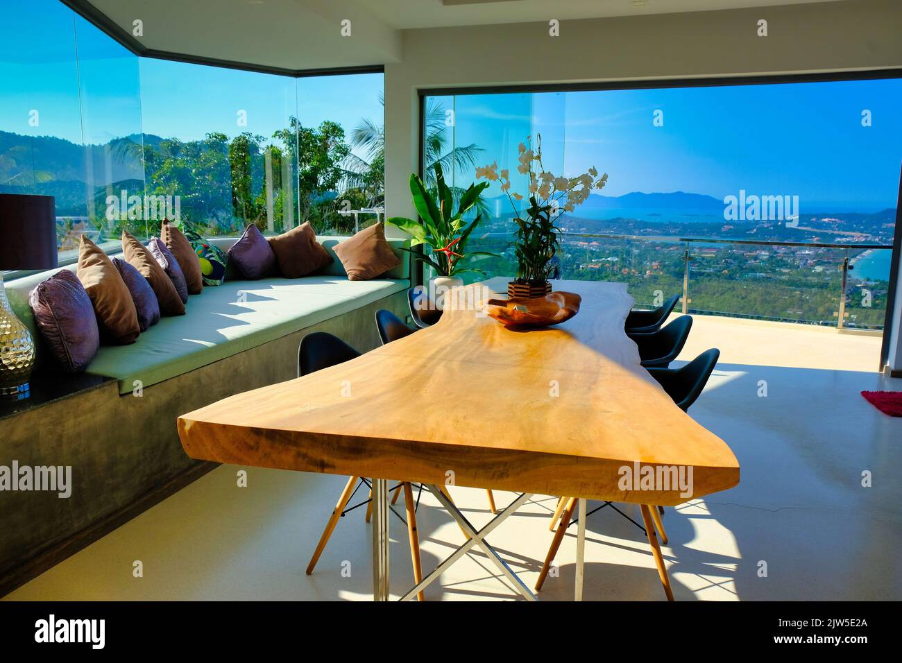 A modern interior of a dining room with panoramic windows looking at a ...