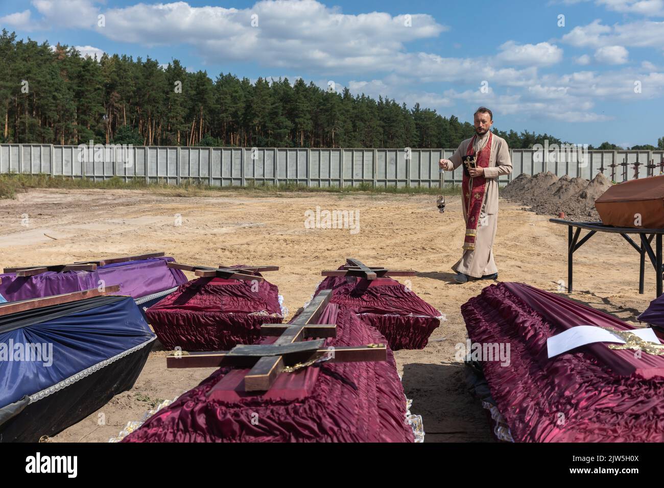 A priest reads a prayer and performs a funeral ceremony for the
