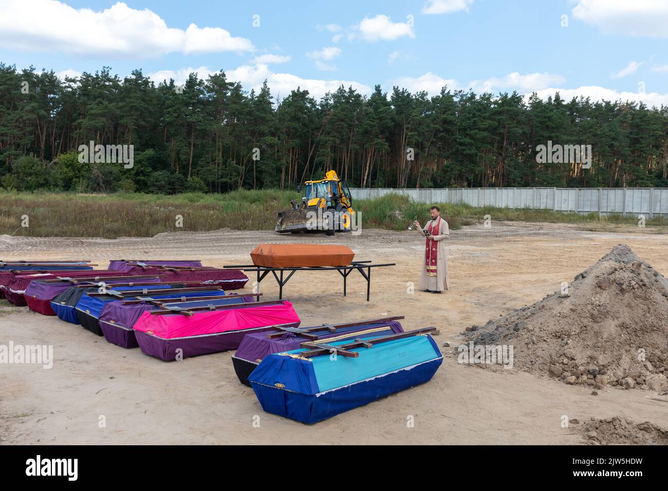 A priest reads a prayer and performs a funeral ceremony for the