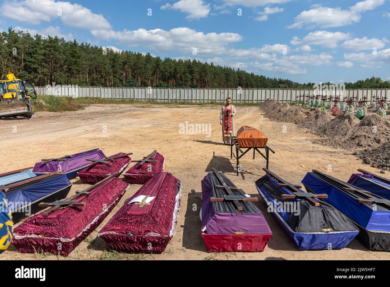 A priest reads a prayer and performs a funeral ceremony for the
