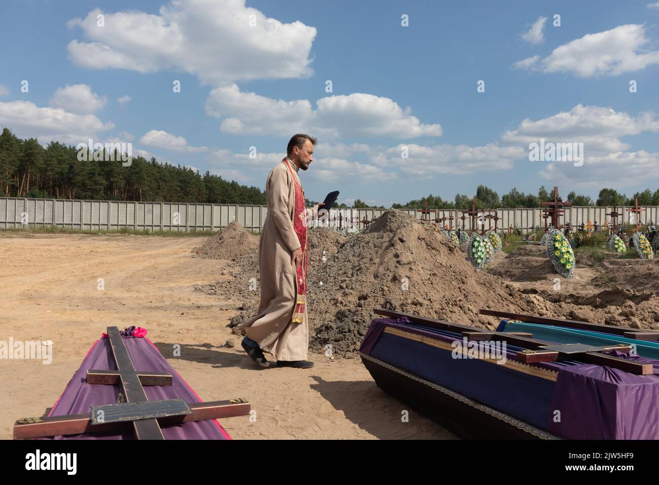 A priest reads a prayer and performs a funeral ceremony for the