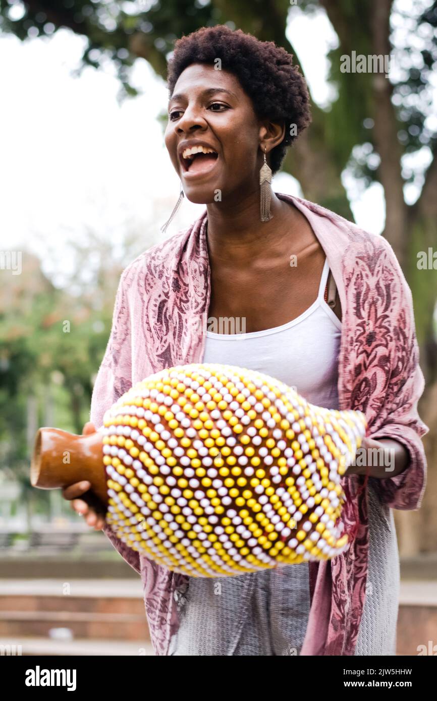 Salvador, Bahia, Brazil - September 17, 2016: Woman playing Abe or Xequere, percussion musical instrument created in Africa. Salvador, Bahia, Campo Gr Stock Photo