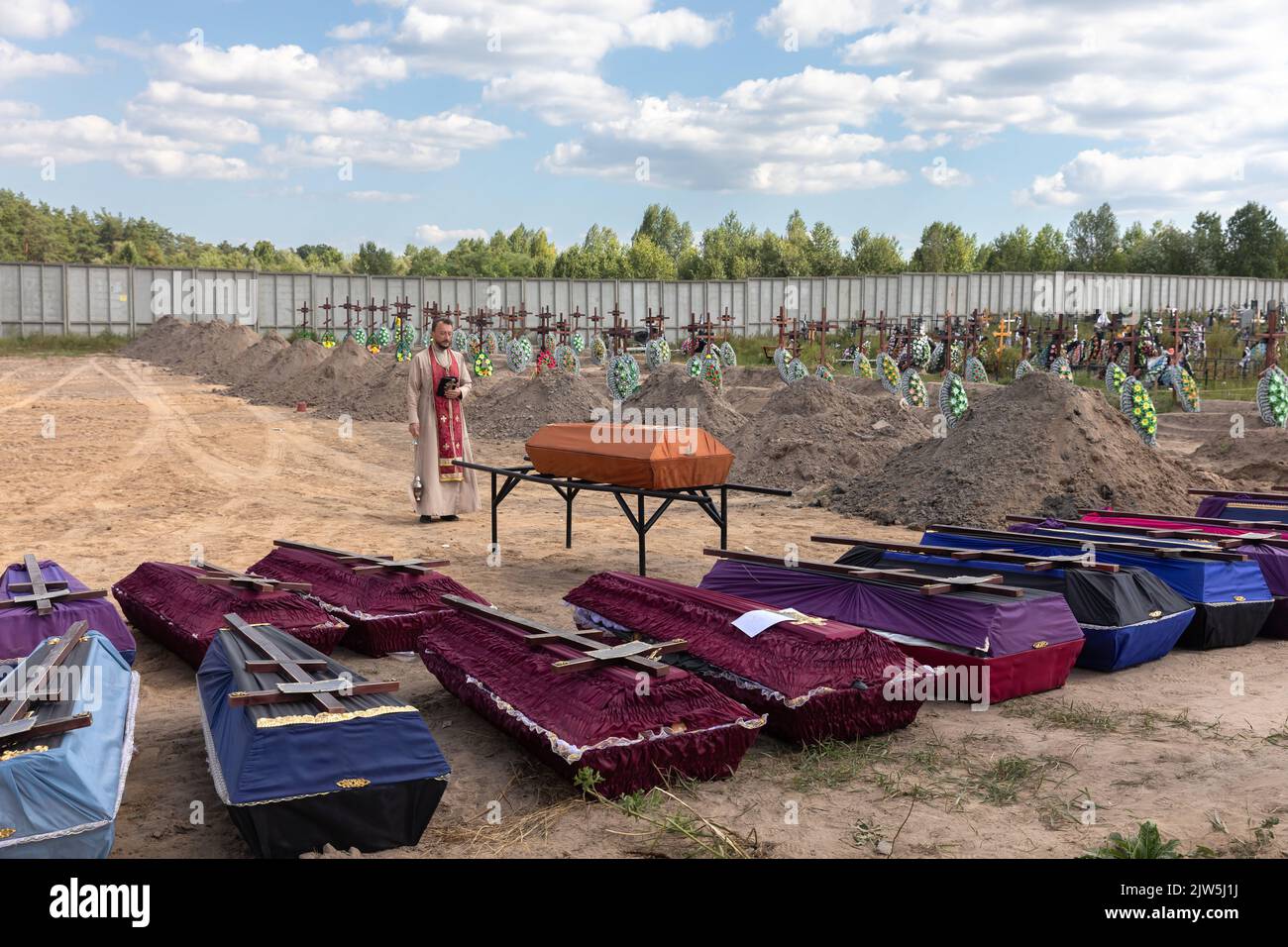 Bucha, Ukraine. 2nd Sep, 2022. A priest reads a prayer and performs a