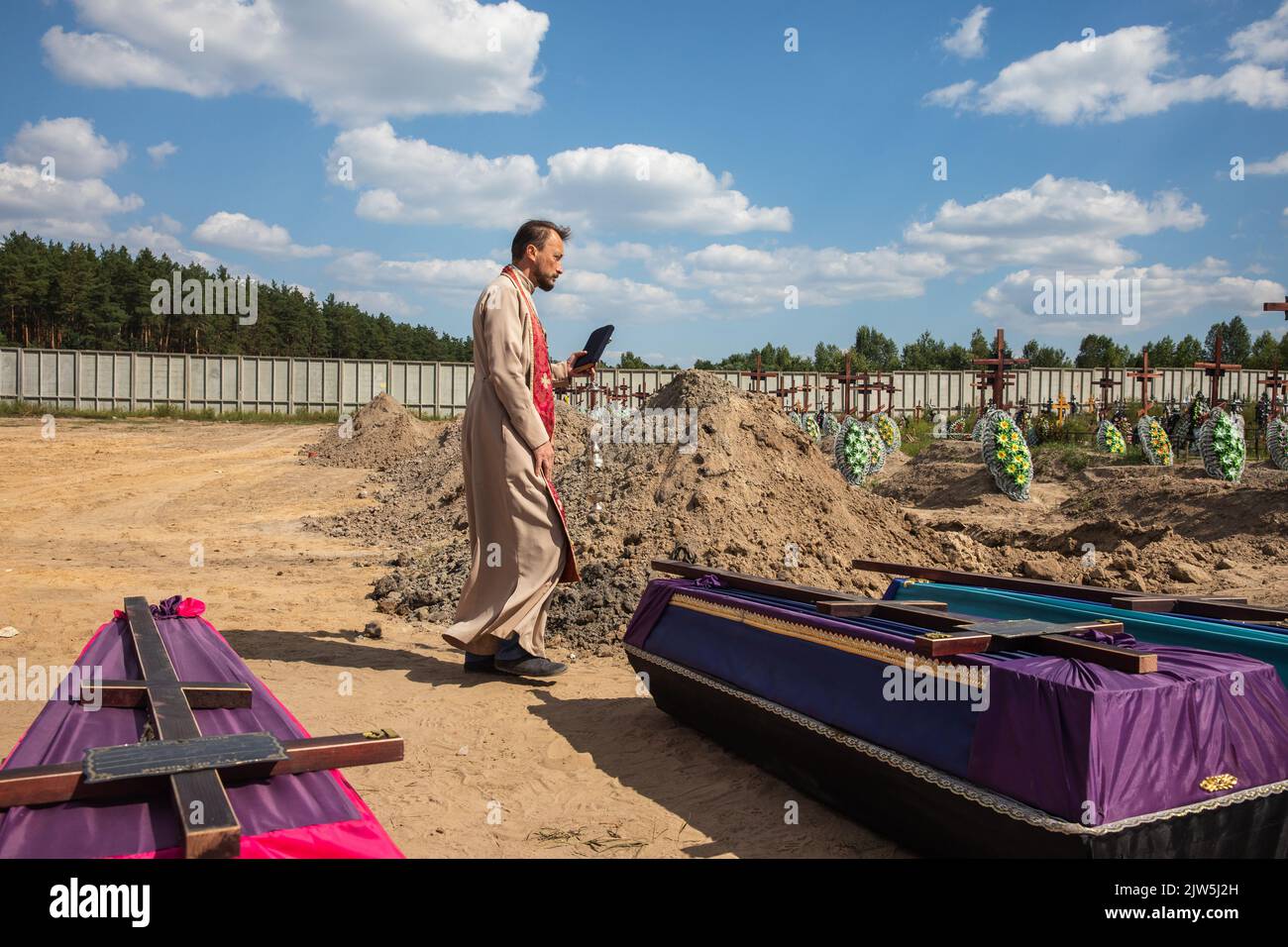 A priest reads a prayer and performs a funeral ceremony for the