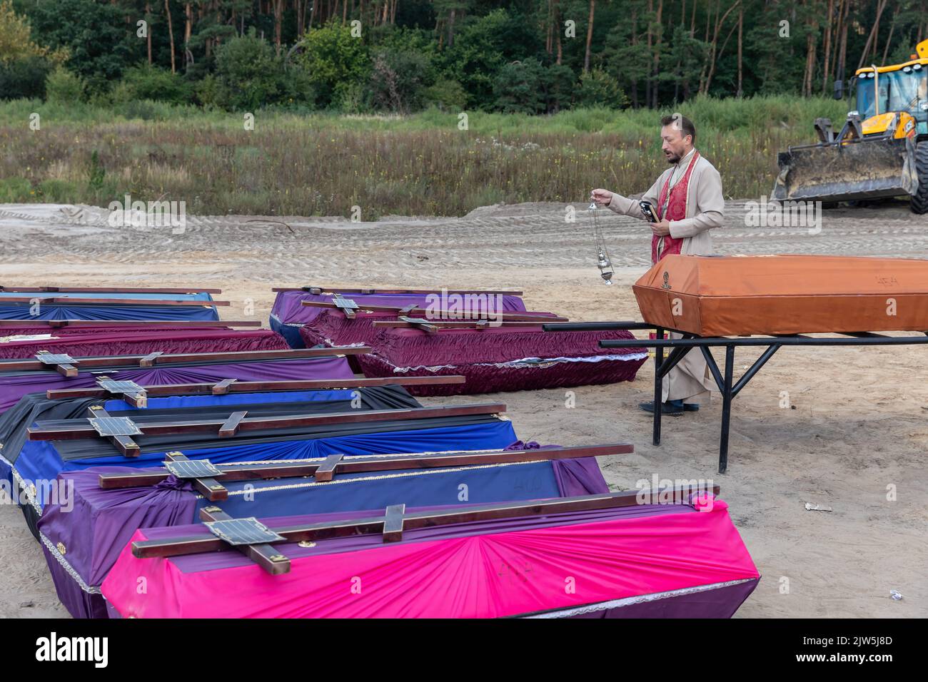 Bucha, Ukraine. 2nd Sep, 2022. A priest reads a prayer and performs a
