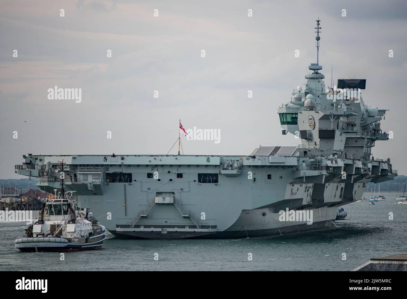 HMS Prince of Wales (R09) being towed into Portsmouth Harbour, UK on 3/9/2022 to undergo further inspection of it's damaged propeller shaft. Stock Photo