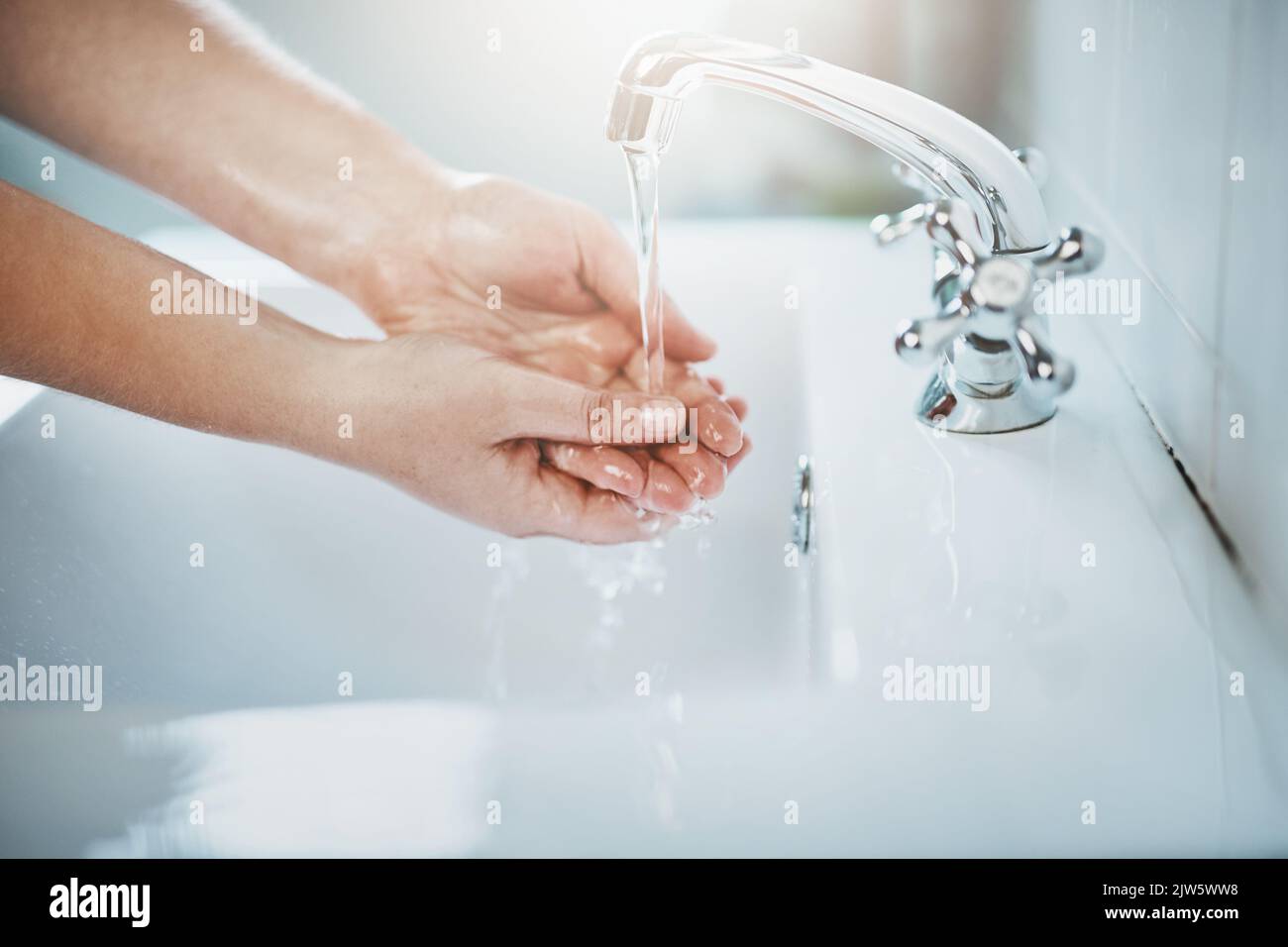 Germs down the drain. hands being washed at a tap. Stock Photo