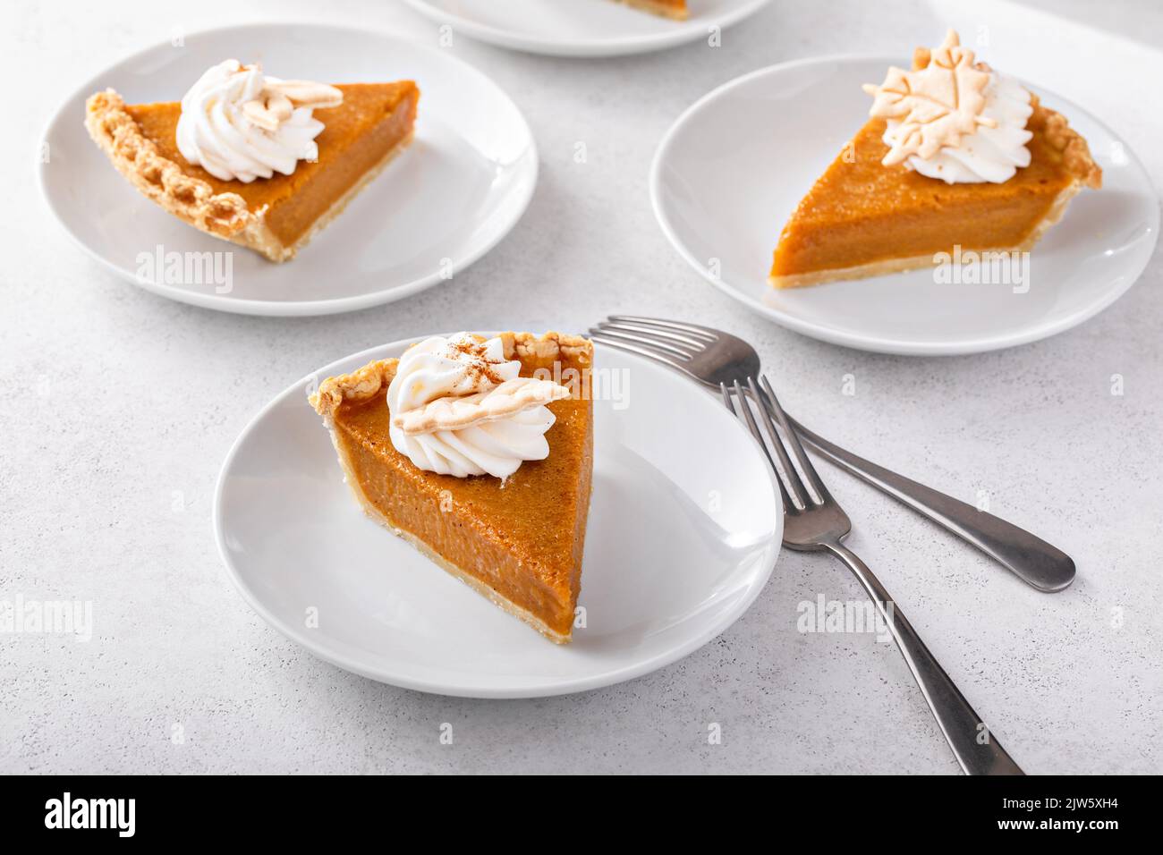Slices of traditional pumpkin pie in a light and bright setting Stock Photo