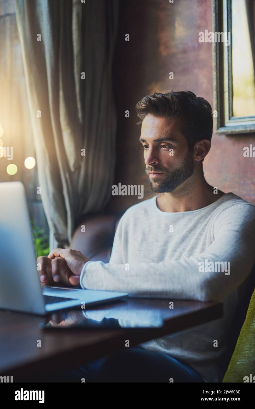Spending his free time in the cafe. a young man using his laptop in a coffee shop. Stock Photo