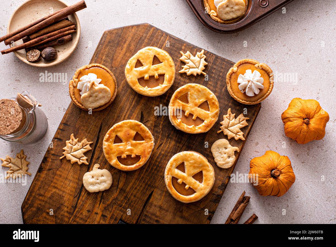 Halloween pumpkin pies with carved pumpkin face on top Stock Photo