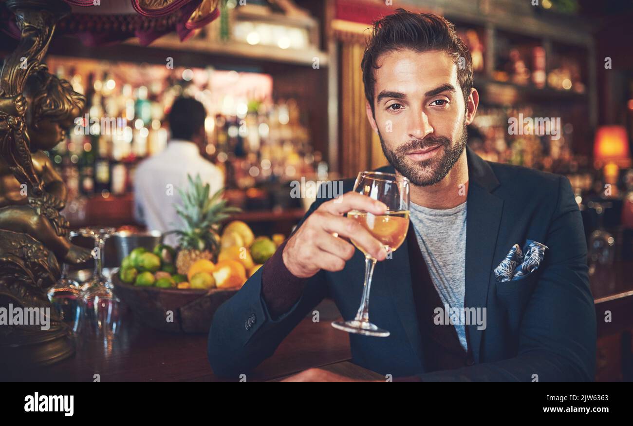 Enjoying a fine wine. a young man sitting in a bar. Stock Photo