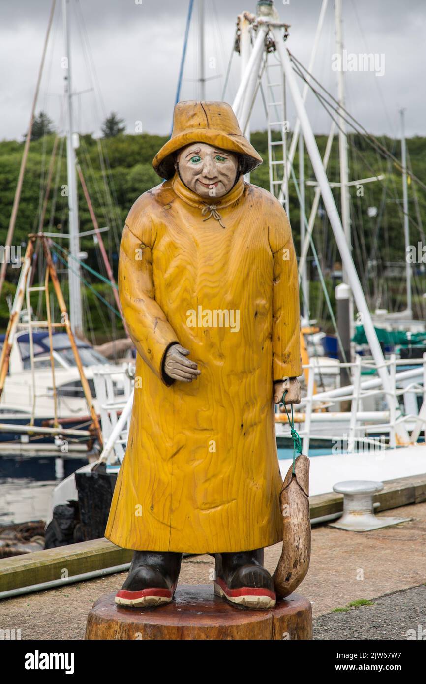 Fisherman statue in yellow oilskin in the harbour of Stornoway, Isle of Lewis, Hebrides, Outer Hebrides, Western Isles, Scotland, United Kingdom Stock Photo