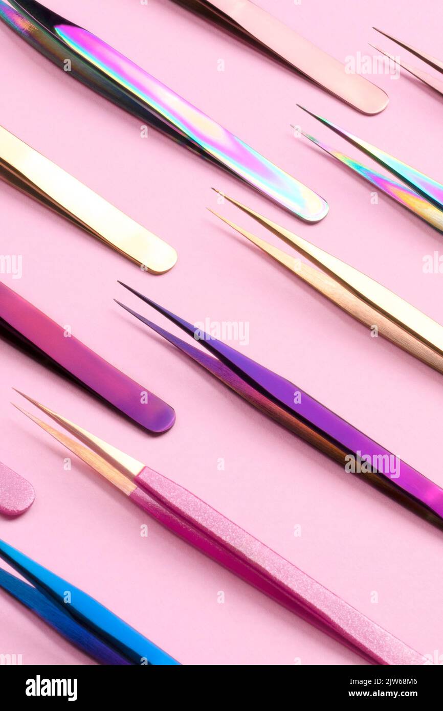 Eyelash tweezers ad with pink background . Commercial photo of colored tweezers . cosmetic product ad. Stock Photo