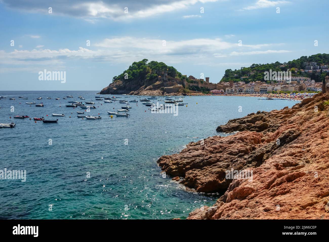 Bay of the Costa Brava with small boats and people enjoying themselves