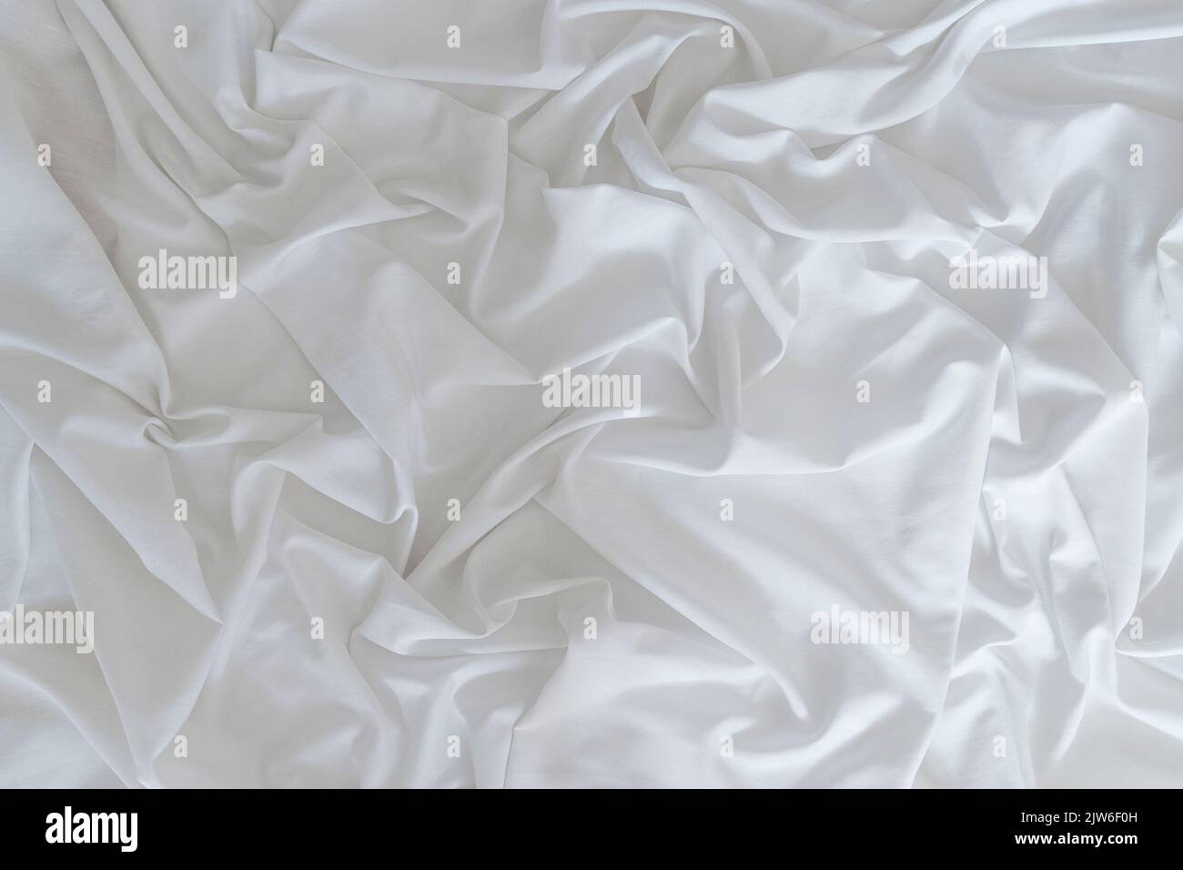 White drapery linen fabric background. Texture of the light surface of